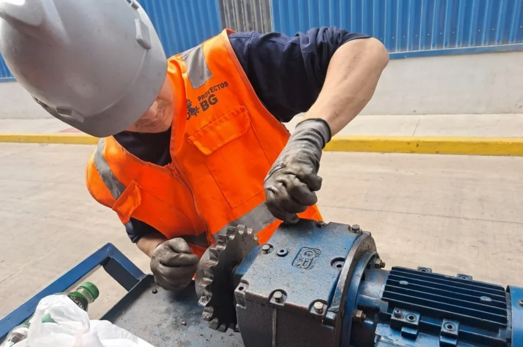 Técnico especialista realizando la reparación y el mantenimiento preventivo de un motor industrial.